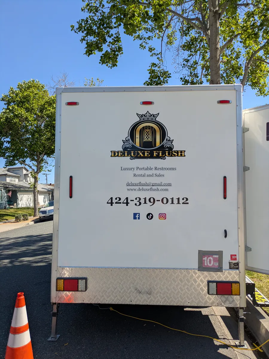 Rear of the Deluxe Flush trailer with gold crest logo and phone number